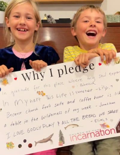 Two children holding a 'Why I pledge' sign at Church of the Incarnation.