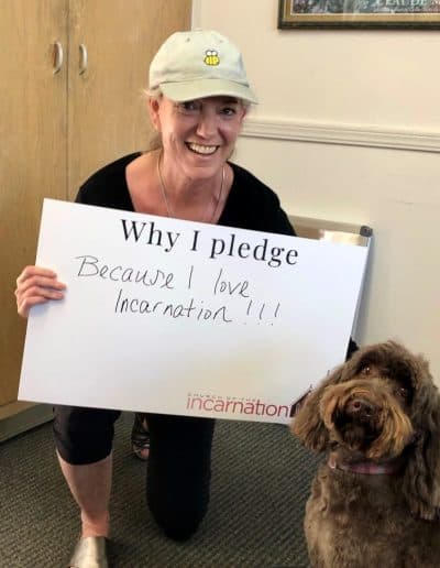 Woman with dog holding pledge sign at Church of the Incarnation.
