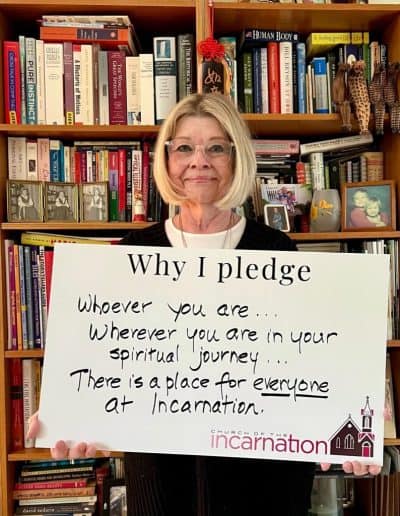 Woman holding a pledge sign about spiritual journey at Church of the Incarnation.