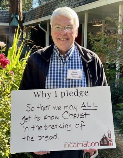 Senior man holding a pledge sign outside Church of the Incarnation.